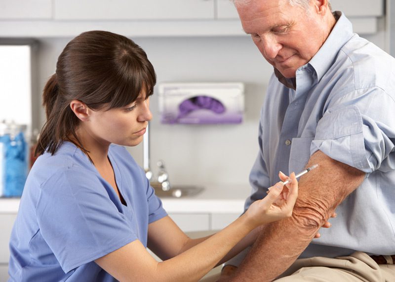 Nurse-giving-injection-to-male-patient
